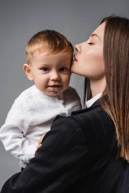 Annesinin yakınındaki kameraya bakan küçük çocuk Grey 'de izole edilmiş.