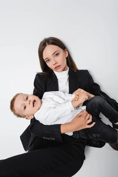 Woman Black Suit Looking Camera While Sitting Happy Baby Boy — 스톡 사진