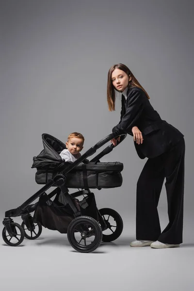 Woman Black Suit Looking Camera Son Baby Carriage Grey — 스톡 사진
