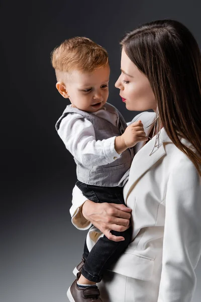 Giovane Elegante Donna Che Tiene Figlio Toccando Sua Collana Grigio — Foto Stock