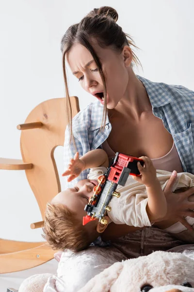 Excited Woman Holding Son Toy Train White — Foto de Stock