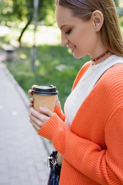幸福的女人拿着纸杯和咖啡一起去的侧视图 — 图库照片