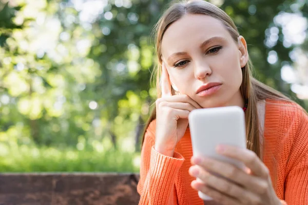 Pensive Woman Using Blurred Smartphone Park — Stok fotoğraf