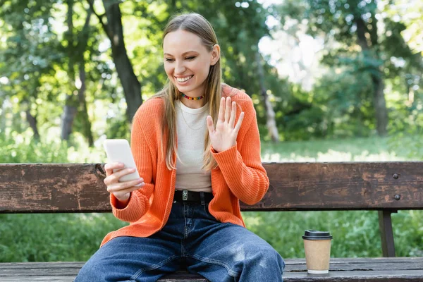 Cheerful Woman Woman Waving Hand Video Call While Sitting Bench — 스톡 사진