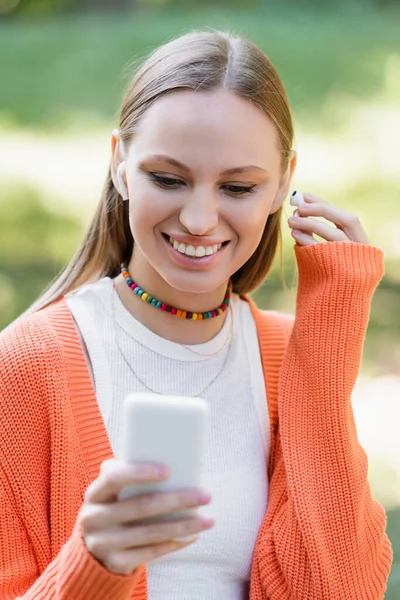 Mulher Feliz Usando Fone Ouvido Sem Fio Usando Smartphone — Fotografia de Stock