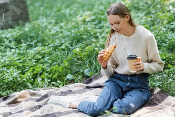 Mujer Vasos Sosteniendo Taza Papel Croissant Mientras Está Sentado Manta — Foto de Stock