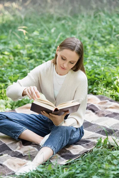 Mujer Leyendo Novela Mientras Está Sentado Manta Alrededor Hierba Parque — Foto de Stock