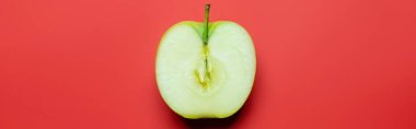 Top view of cut green apple on red background, banner 