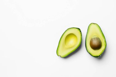 Top view of ripe and cut avocado on white background