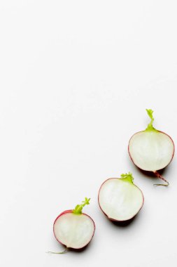 Top view of fresh cut radishes on white background with copy space clipart