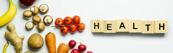 Вид сверху на свежие продукты возле кубиков со здоровой повязкой на белом фоне, баннер 