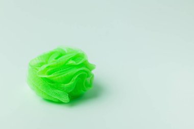 bright green mesh washcloth on grey background