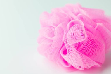 close up view of pink mesh washcloth on grey background