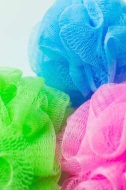 close up view of pink, green and blue mesh sponges isolated on grey