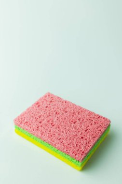 porous pink, green and yellow sponge rugs on grey background with copy space clipart