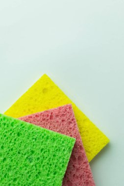 top view of textured colorful sponge cloths on grey background