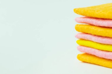 close up view of yellow, pink and orange cloth napkins on grey background with copy space