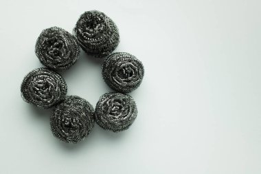 top view of circle made of stainless steel scourers on grey background