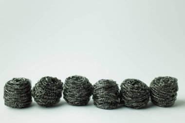 row of abrasive metal scourers on grey background with copy space clipart