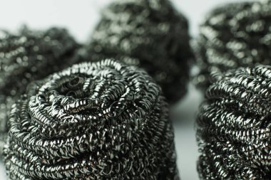 close up view of abrasive metal scourers on grey background clipart