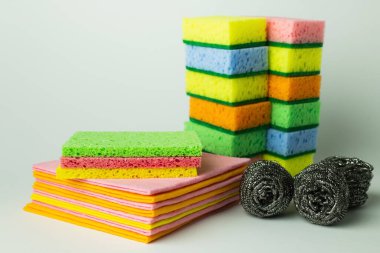 bright sponge scourers, dishrags and metal scrubbers on grey background