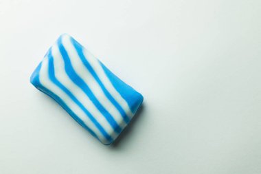 Gri arkaplanda mavi ve beyaz çizgili banyo sabunlarının üst görüntüsü