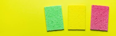 top view of bright absorbent sponge rugs on yellow background, banner clipart