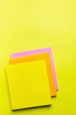 top view of colorful fabric napkins on bright yellow background
