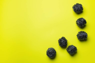 Sarı zemin üzerindeki paslanmaz scourers üst görünümü kopyalama alanı ile