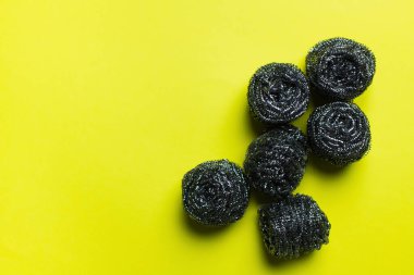 top view of cleansing steel scourers on yellow background