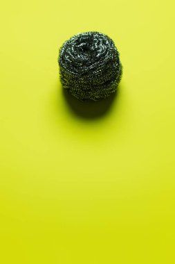 top view of cleansing wire scrubber on yellow background with copy space