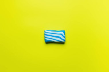 top view of blue and white soap on yellow background with copy space