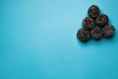 triangle of cleansing metal scrubbers on blue background, top view