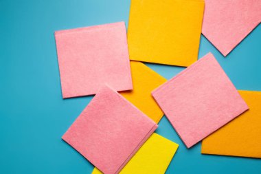 top view of colorful and soft dishrags on blue background