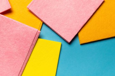 top view of soft multicolored rags on blue background, top view