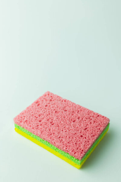 porous pink, green and yellow sponge rugs on grey background with copy space