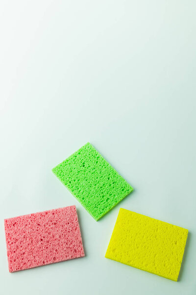 top view of bright multicolored sponge cloths on grey background with copy space