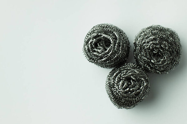 top view of three stainless wire scourers on grey background