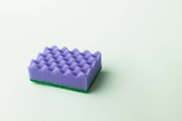 bright purple textured sponge scourer on grey background 