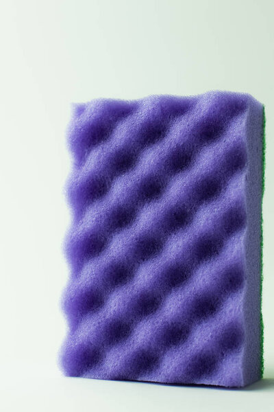 close up view of purple kitchen sponge on grey background