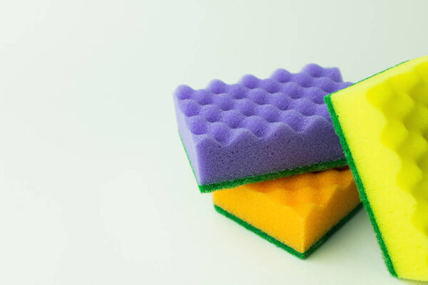 purple, orange and yellow sponges on grey background