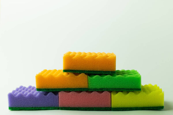 multicolored sponge scourers stacked on grey background
