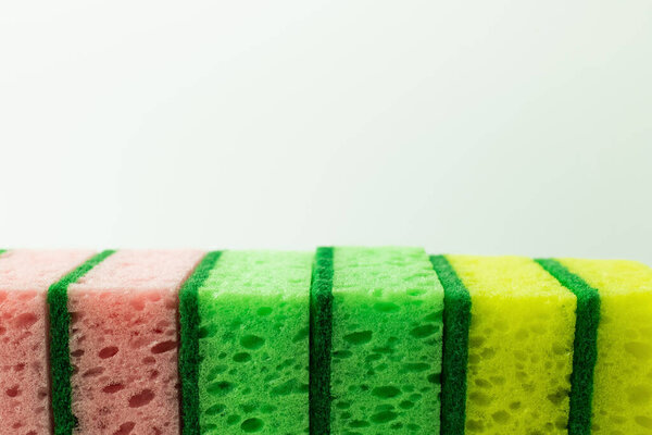 close up view of pink, green and yellow porous sponges isolated on grey