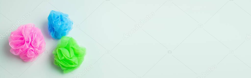 top view of multicolored body puffs on grey background, banner