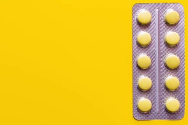 top view of blister pack with pills isolated on yellow