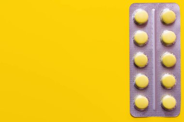top view of blister pack with pills isolated on yellow clipart