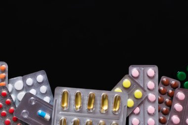 Siyaha izole edilmiş farklı haplarla dolu su toplayıcı paketlerinin üst görüntüsü