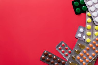 Kızıla izole edilmiş farklı haplarla dolu su toplayıcı paketlerinin üst görüntüsü