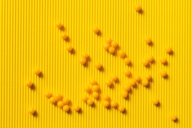 top view of round shape medication on yellow textured background