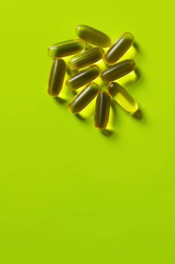 top view of jelly supplement capsules on green background  clipart